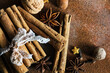 Christmas spices. Christmas composition with cinnamon sticks; anise stars, nutmeg, cloves, hazelnut and dried orange slices on dark background. Copy space for your text. Rustic vibe.