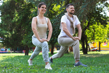 Canvas Print - Man and woman doing morning exercise in park