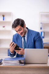 Poster - Young male employee drinking alcohol at workplace