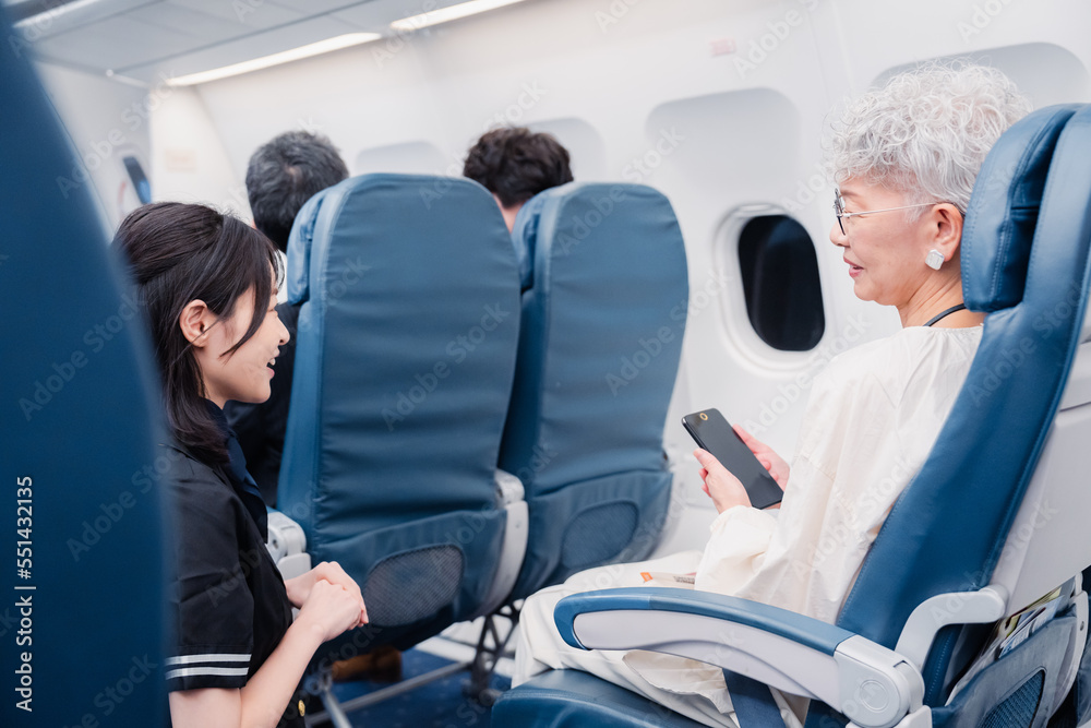 高齢の乗客を案内するキャビンアテンダント の Stock フォト | Adobe Stock