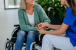 © Halfpoint - Close-up of woman doctor consoling of senior woman at wheelchair.