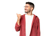 © luismolinero - Young handsome caucasian man over isolated chroma key background pointing to the side to present a product