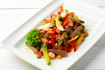 Wall Mural - Beef salad with vegetables served on white plate