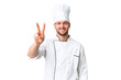 © luismolinero - Young caucasian chef over isolated chroma key background smiling and showing victory sign