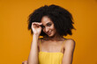 Young beautiful smiling shy curly woman looking at camera
