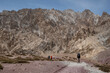 © monswi - mountain trekkers walking with backpacks through the Himalayas. Raw mountain landscape with people in the background.