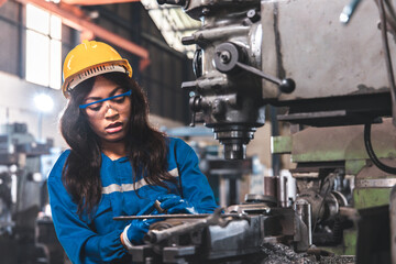 young woman smiling and working engineering in industry.Portrait of young female worker in the factory.Work at the Heavy Industry Manufacturing Facility