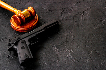 Gun law concept. Hand gun weapon and judges gavel. Crime background