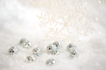 Canvas Print - Christmas snowflake and small mirror balls on a white snow. Blurred background with beautiful bokeh. Shallow depth of field. Copy space. Airy atmosphere. Soft focus. 