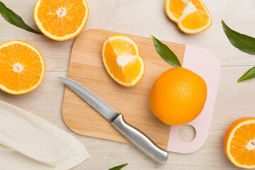 Fresh oranges with leaves on wooden background