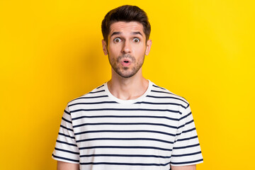 Poster - Portrait of young handsome student man wear striped white black t-shirt pouted lips surprised secret information isolated on yellow color background