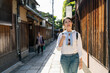 © PR Image Factory - smiling asian girl traveler taking leisure walk and enjoying retro vibe on the beautiful Ishibeikoji lane while visiting the historic area in gion Kyoto japan on a sunny day