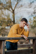 © ADDICTIVE STOCK - Pensive man standing on wooden bridge