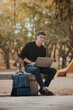 © ADDICTIVE STOCK - Happy man working on laptop in park