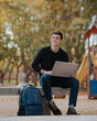 © ADDICTIVE STOCK - Happy man working on laptop in park