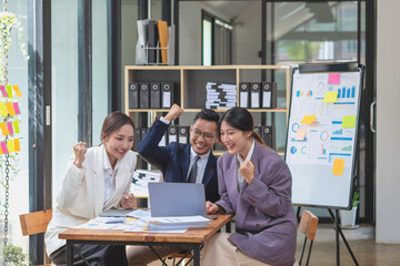 Team of Asian businessmen helping to brainstorm management ideas for the company are expressing joy and happiness that the company has achieved commercial success.