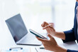 © amnaj - Woman using smartphone play social media application and conduct mobile banking.