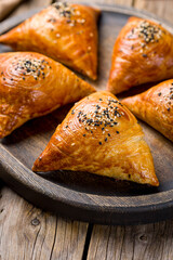 Wall Mural - Samsa national uzbek food on old wooden table vertical, macro close up