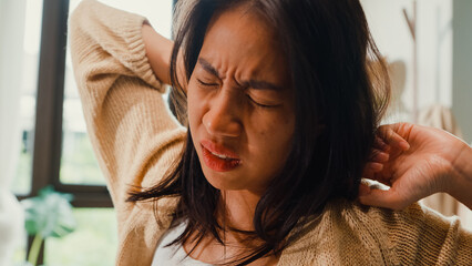 Close-up Asian girl with white cream pajamas sleep on pillow wake up sleepy lazy and stretching arm muscle on fluffy bed in bedroom holiday morning light from window. Female morning vibes concept.