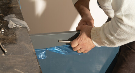 Wall Mural -  Worker fixing kitchen cabinet using screwdriver.