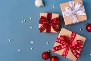 Wall Mural - Gift boxes with Christmas decorations on blue background. Top view.