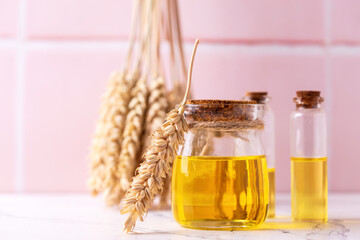 Canvas Print - Bottles with organic wheat germ oil against pink tiled wall.  Natural skin care products. Beauty blogging, salon treatment concept. Selective focus. Place for text.