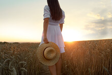 Beautiful Young Woman With Straw Hat In Ripe Wheat Field At Sunset, Closeup