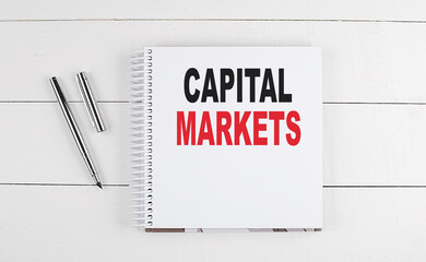 Poster - CAPITAL MARKETS text written on notebook on the wooden background