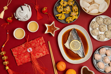 Wall Mural - Chinese new year festival table over red background. Traditional lunar new year food. Flat lay, top view