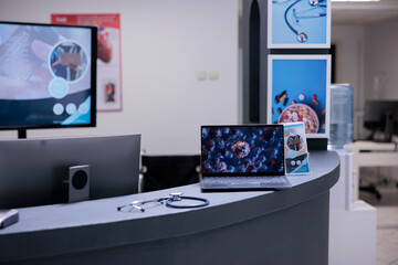 Wall Mural - Coronavirus vaccination center showing illustrative images of covid 19 cell on laptop screen at administrative area. Medical clinic informing about coronavirus symptoms through representation on