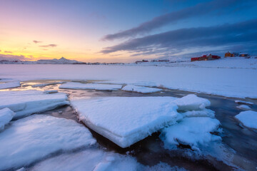 Wall Mural - north, norway. winter landscape during sunset. bright sky. ice and snow on the shore. reflections on