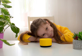 girl talks to Alexa virtual assistant and gives her orders and commands what to turn on. The child uses smart speaker with voice control. Educational program for child