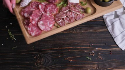 Wall Mural - Woman putting wooden cutting board with Traditional Sliced fuet salami sausage