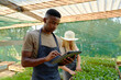 © StratfordProductions - Young multiracial couple using digital tablet while examining plants in plant nursery