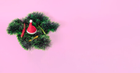 Wall Mural - Christmas garland, Santa´s hat and hot peppers on pink background