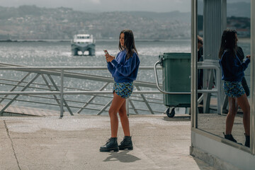 hispanic latina girl in the seaport with the mobile phone