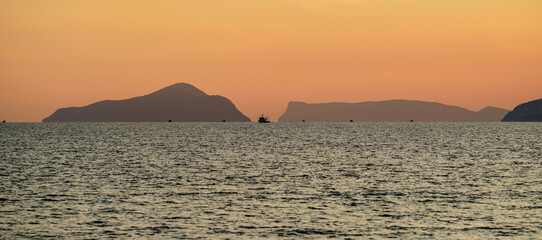 Wall Mural - Tisan Dana Island in sunset and some boats seem barely far away, selective focus, Mersin Turkey