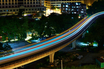 Wall Mural - Light rail transit train moving through the city in the night