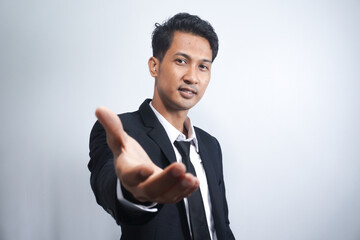 Confident businessman extending hand for handshake, greeting business partner and smiling, standing over white background