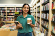 © AntonioDiaz - Happy woman reader carrying books and a coffee at the bookstore
