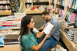 © AntonioDiaz - Couple reading a novel together while shopping at the book store