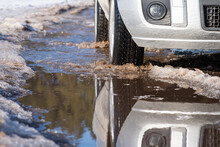 Front Part Of Car On The Muddy Road With Ponds. Spring, Thaw, Mash Of Snow And Water On The Tracks