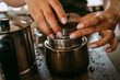 © Maskot - Hands of female entrepreneur preparing coffee in studio