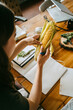 © Maskot - High angle view of female food stylist examining fresh corn at table in studio