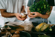 © Maskot - Midsection of male and female entrepreneurs holding mushrooms by jar with seeds at studio kitchen