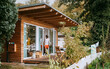 © Maskot - Mature man standing at doorway of tiny house