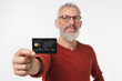 © InsideCreativeHouse - Closeup focused photo of middle-aged mature man holding credit card in front of the camera with copyspace for loan debt cashback online shopping e-commerce e-banking isolated in white background