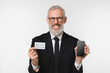 © InsideCreativeHouse - Smiling caucasian mature middle-aged businessman ceo boss bank employee worker using cellphone with mockup e-banking, e-commerce, holding credit card with copy space