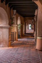 A Long Outside Corridor With Rustic Arches Creates A Vanishing Point Effect