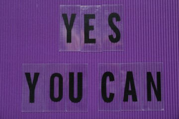 Wall Mural - Phrase Yes You Can of plastic letters on purple background, top view. Motivational quote
